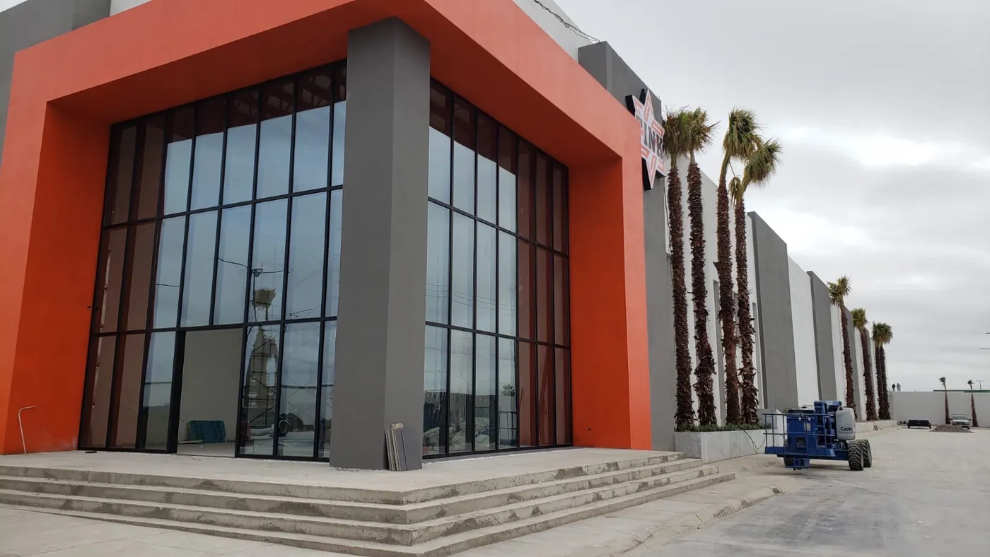 Fachada de cristal en obra comercial con marco naranja