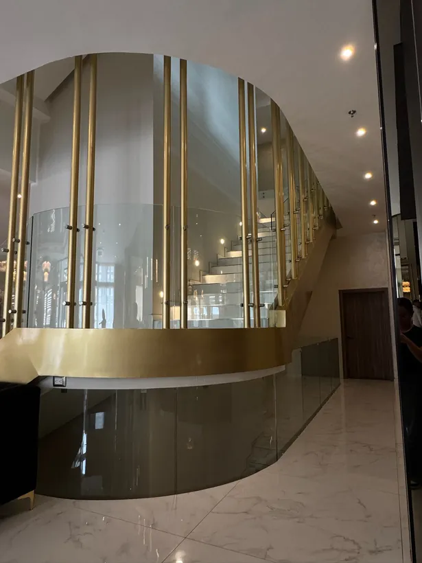 Cristal curvo con perfiles dorados en el lobby del Hotel Don Rubén